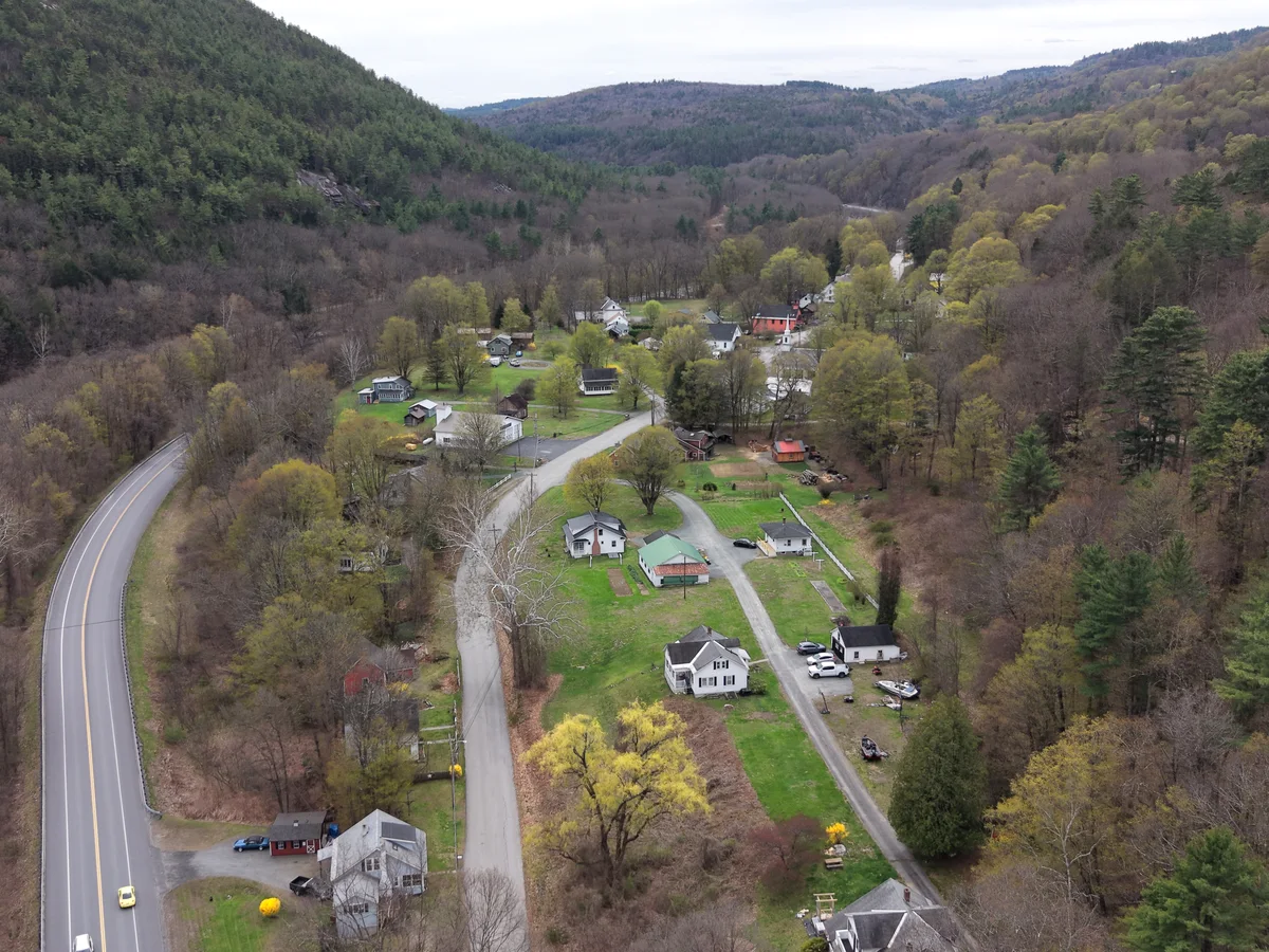 Aerial drone view of a small Vermont village nestled in a mountain valley in spring