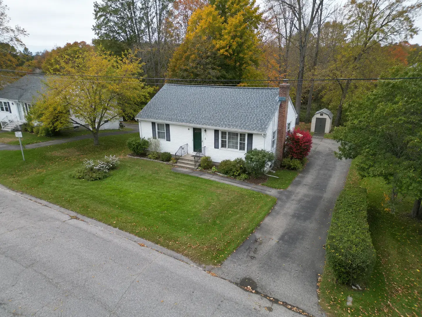 Aerial drone view of a starter home in New England fall foliage